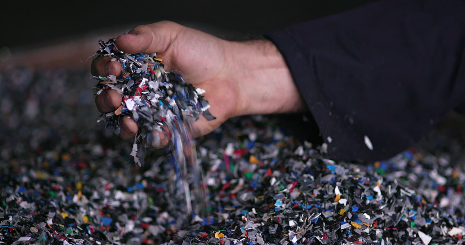 Hand holding ground up plastics